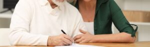 padre firmando un testamento en presencia de su hija que va a ser su heredera
